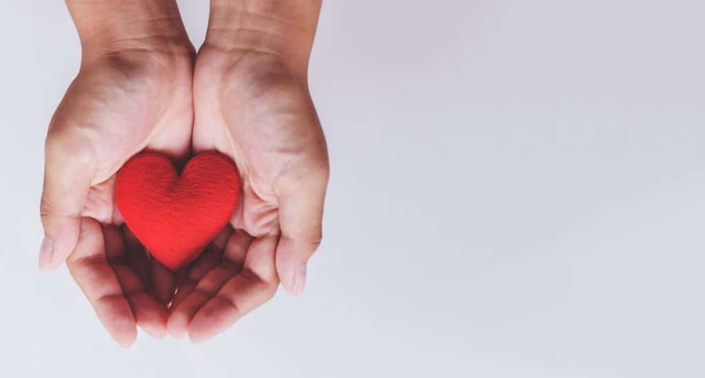Hands holding a heart that represents hospice care