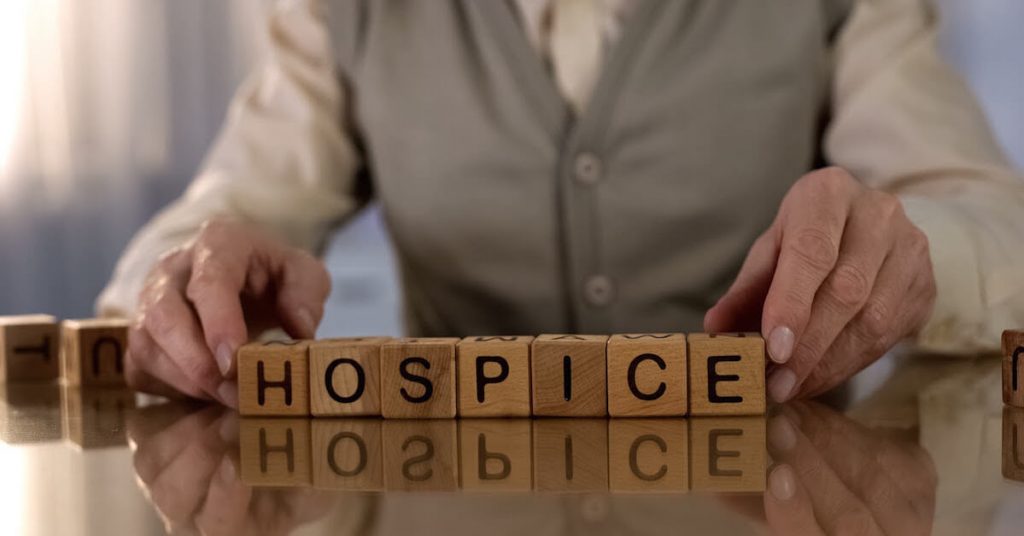 Man in hospice holding blocks that say hospice