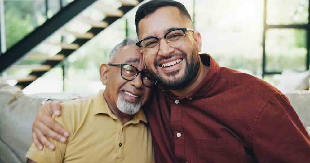 Happy senior father and middle-aged son who are benefitting from hospice respite care.