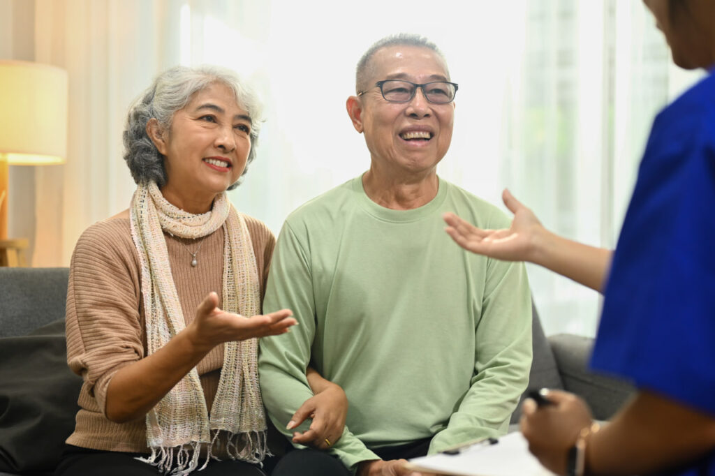 Confident senior man and woman discussing information with a hospice social worker.