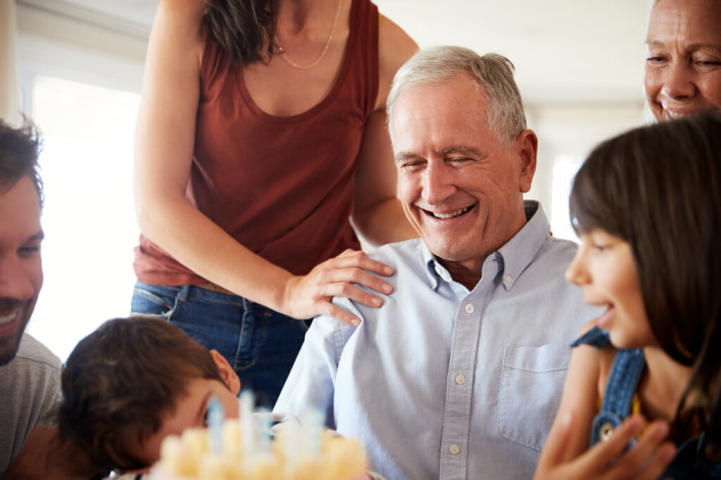 Man celebrating a birthday as his family celebrates what does it mean when someone is in hospice.